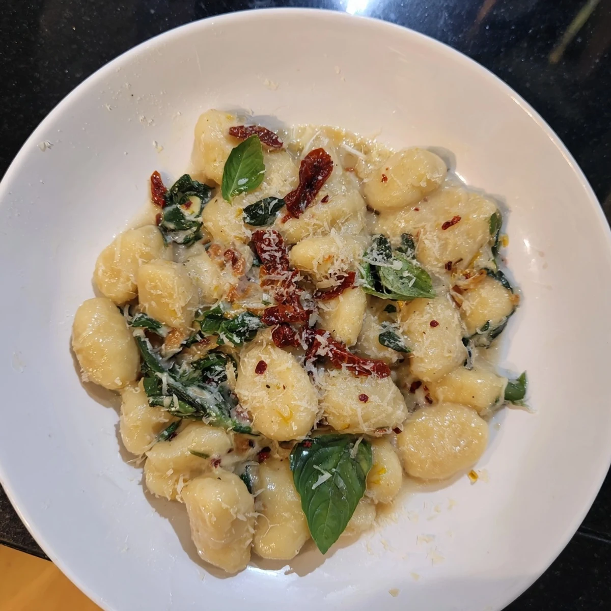 Picture a vibrant plate of creamy Tuscan gnocchi, garnished with fresh basil, ready to enjoy.