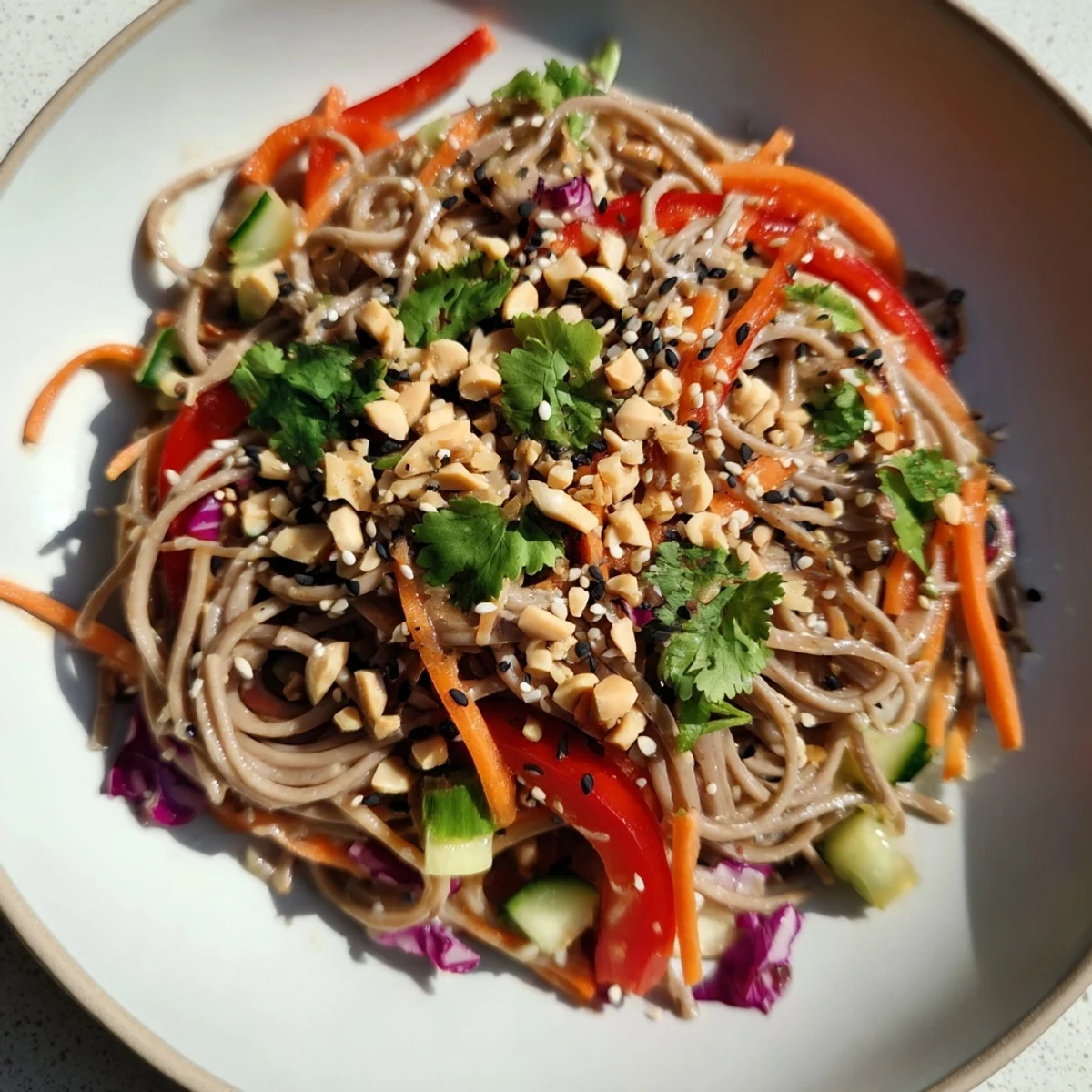 A vibrant bowl of cold noodle salad with sesame-ginger dressing, ready to be enjoyed.