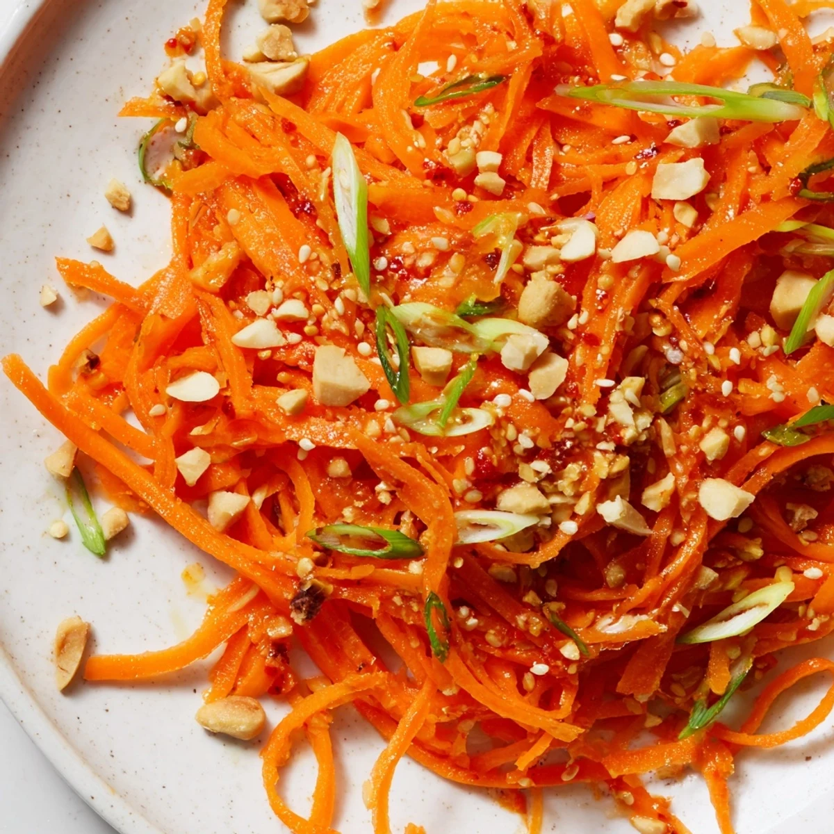 Vibrant Spicy Carrot Salad: A colorful mix of shredded carrots in a spicy sesame dressing.