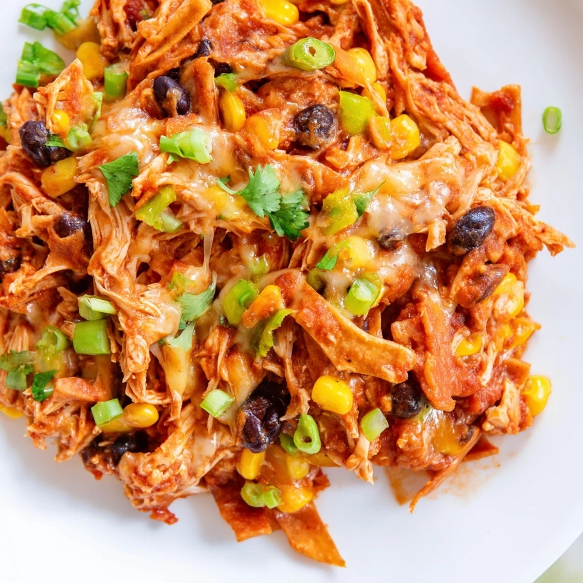 View a close-up of a bubbling Chicken Enchilada Skillet, showing melted cheese and crispy tortilla strips.