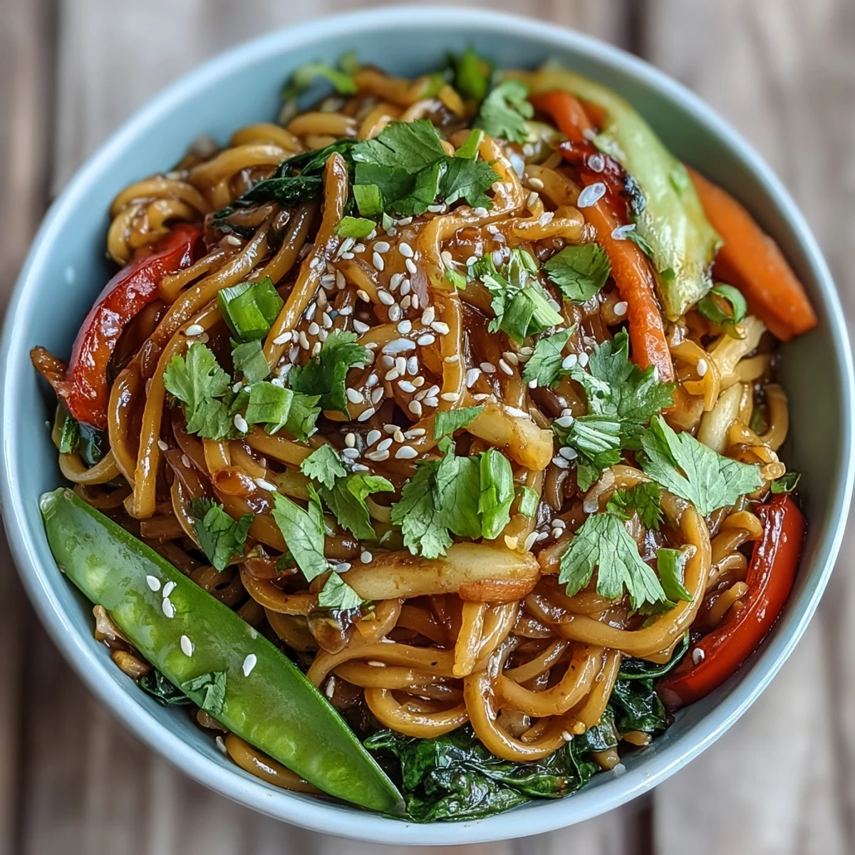 Quick vegan stir-fry of shirataki noodles with vibrant red bell peppers, bok choy, snow peas, and carrots, finished with a savory Asian ginger glaze.