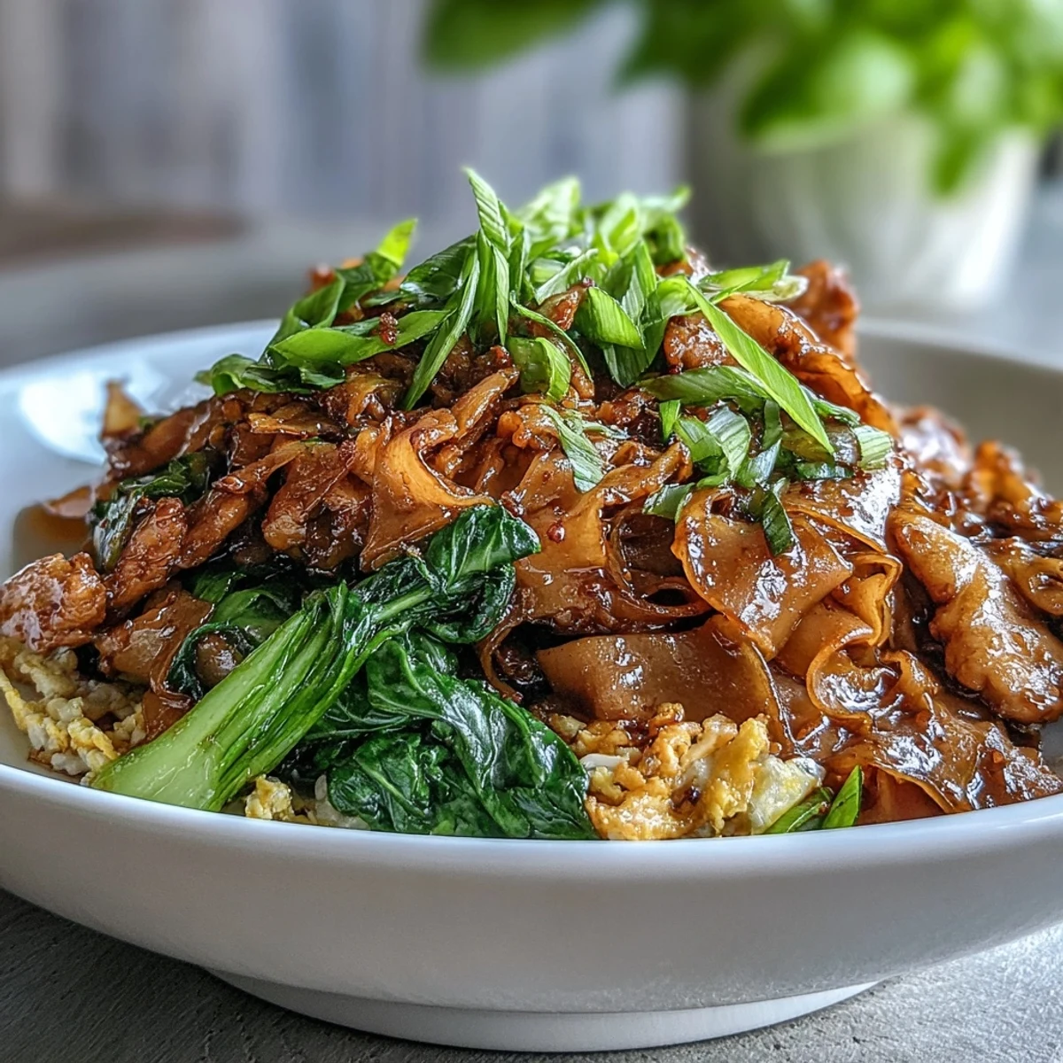Steaming Authentic Thai Pad See Ew is plated with lime wedges, showcasing glossy noodles, chicken, and crunchy Chinese broccoli for a street-food feast.