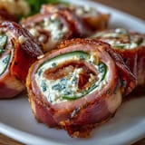 Savory ham, cream cheese, and pickle pinwheels arranged on a white platter, perfect for parties or quick snacks.