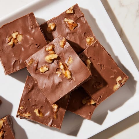 This decadent Easy Chocolate Fudge shows a perfectly cut square, ideal for dessert cravings.