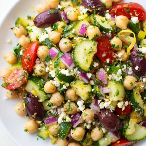Bright, fresh Mediterranean Chickpea Salad, showcasing juicy tomatoes, olives, and creamy feta, ready to serve.