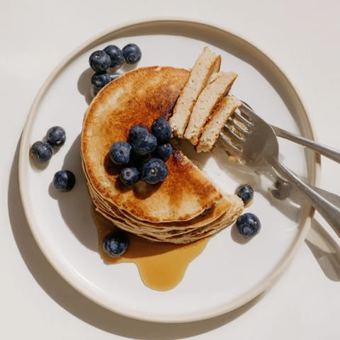 Protein Power Pancakes served warm, topped with fresh blueberries and a dollop of Greek yogurt.