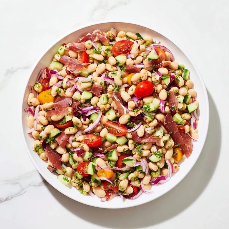 Prepared Dense Bean Salad with Prosciutto featuring fresh herbs, ready for a delicious lunch or dinner.