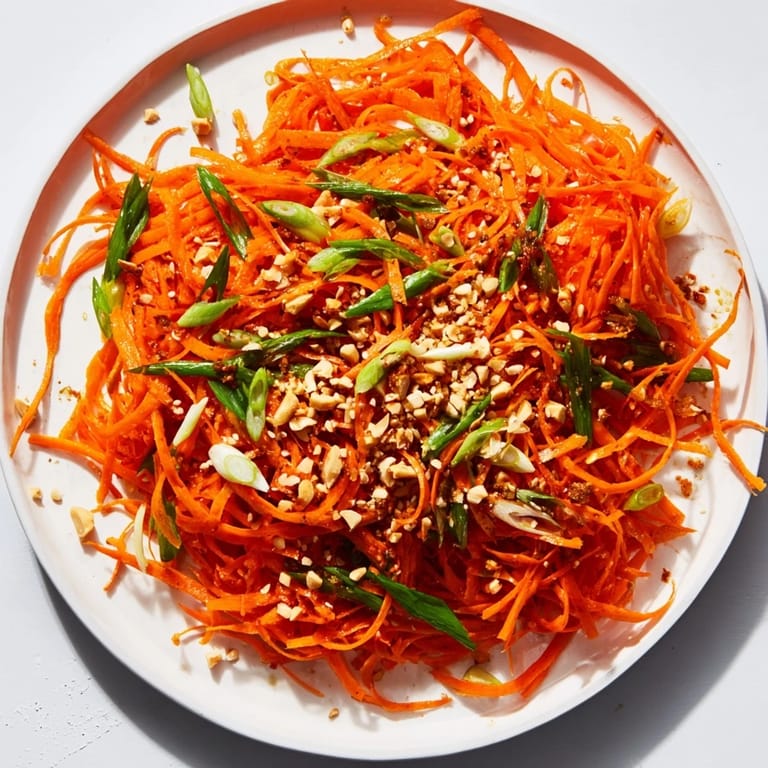 Close-up of Spicy Carrot Salad featuring bright orange carrots with a flavorful, tangy sauce.