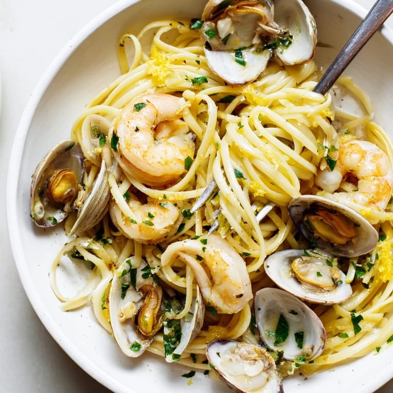 Close-up of Seafood Linguine featuring plump shrimp and mussels over al dente pasta, with a light lemon and white wine sauce.