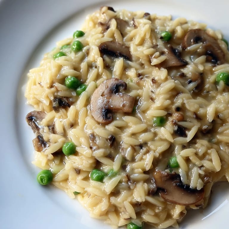 Hearty Orzo Mushroom Risotto-Style cooking in a skillet, featuring a creamy texture and golden brown mushrooms.