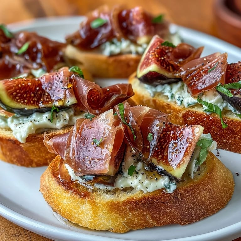 Italian crostini with prosciutto and fresh figs, garnished with thyme for an elegant, flavor-packed bite.  